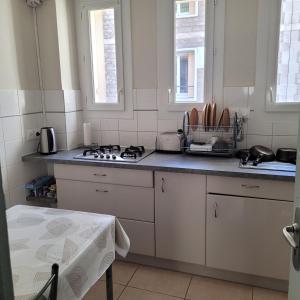 a kitchen with a sink and a stove top oven at 2 chambres chez l'habitant in Poitiers