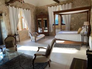 a bedroom with a bed and a table and chairs at Manoir La Barriere - Lot in Le Vigan