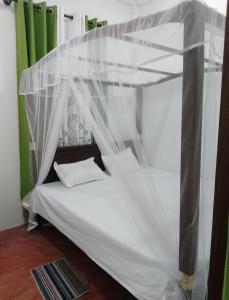 a bed with a canopy in a room at Villa kandupamula in Mirissa