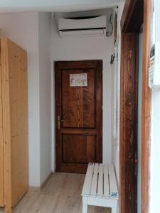 a room with a wooden door and a bench at Pensiunea Geostar in Curtea de Argeş