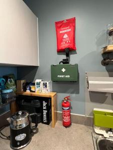 a kitchen with a stove and a fire extinguisher on the wall at A cosy apartment near Crawley Station/Gatwick Airport in Crawley