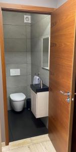 a bathroom with a toilet and a wooden door at Appartement Mimosa Croisette in Cannes +22 photos