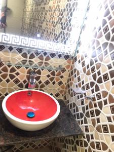 a bathroom with a red sink on a counter at Burj A Zafar in Murree