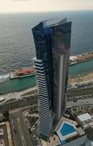 an aerial view of a tall building next to the ocean at برج داماك in Jeddah