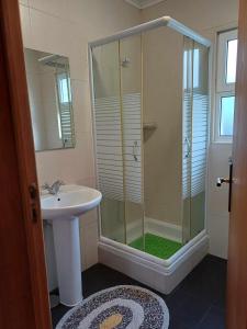 a bathroom with a glass shower and a sink at Quinta das rãs in Ponta Delgada