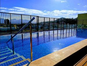 a swimming pool with blue water and a fence at Rio De Janeiro Freguesia Jacarepaguá Lotf in Rio de Janeiro
