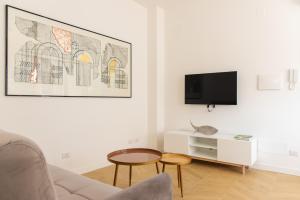 een woonkamer met een bank en een tv aan de muur bij Eur Laghetto casa vista lago Fattori in Rome