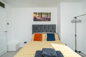 ein Schlafzimmer mit einem Bett mit bunten Kissen in der Unterkunft Private Room in London Enfield with parking in Enfield