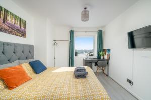 Schlafzimmer mit einem Bett, einem Schreibtisch und einem TV in der Unterkunft Private Room in London Enfield with parking in Enfield