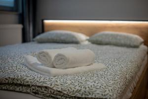 two towels and two pillows on a bed at Apartments Częstochowa - Nova Bursa - Prywatny parking! in Częstochowa +18 photos