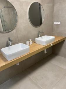 a bathroom with two sinks and a mirror at JAMY HOUSE Apartmán in Habovka