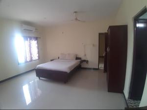a bedroom with a bed in a room with a window at Renu Residency on the way to Isha Yoga Centre- Adiyogi near Maruthamalai in Marudhamalai