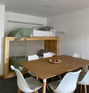 a table and chairs in a room with a bunk bed at Natagonia Apartments in Puerto Natales