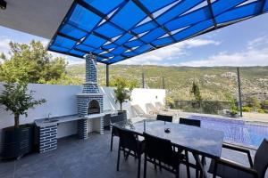 um pátio com uma mesa e cadeiras e uma piscina em Villa Serengeti / Kalkan em Kas