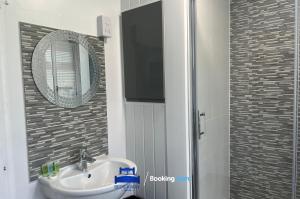 a bathroom with a sink and a mirror and a shower at 3 Bedroom Cosy Bungalow By Beds Away Short Lets & Serviced Accommodation Chalgrove With Outdoor Dining Area in Chalgrove