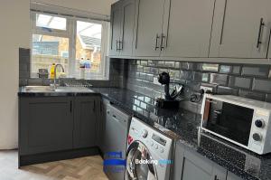 a kitchen with a washer and dryer in it at 3 Bedroom Cosy Bungalow By Beds Away Short Lets & Serviced Accommodation Chalgrove With Outdoor Dining Area 