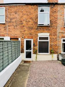 a brick building with a white door and windows at Stylish cottage - Parking for 2 cars! in Lincolnshire