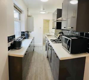 a kitchen with a counter top with a microwave at Stylish cottage - Parking for 2 cars! in Lincolnshire