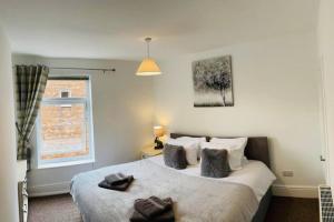 a bedroom with a bed with two towels on it at Stylish cottage - Parking for 2 cars! in Lincolnshire