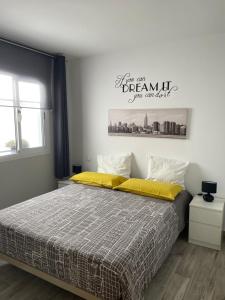 - une chambre dotée d'un grand lit avec des draps jaunes dans l'établissement Apartamento Don Carlos, à Tarajalejo
