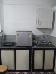 a small kitchen with a sink and a refrigerator at Mendonca's Home Stay in Pernem