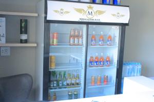 a refrigerator filled with lots of bottles of drinks at MOHALALITOE B and B in Maseru
