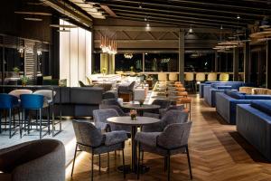 um restaurante com cadeiras e mesas e um bar em Grand Hotel Millennium Sofia em Sófia