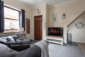 a living room with a couch and a television at Promenade Apartments Maldon in Maldon