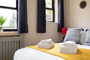 a bedroom with a bed with towels on it at Promenade Apartments Maldon in Maldon