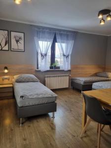 1 dormitorio con 2 camas, mesa y sidx sidx sidx de mesa en Przystań, en Rozalin