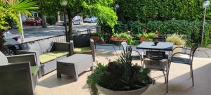 un patio con tavolo, sedie e piante di Hotel Ardesia a Rimini