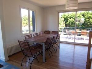 a dining room with a wooden table and chairs at Maison Spacieuse à Carnac - 4 Chambres, Terrasse et Jardin, Proche Plage et Commerces - FR-1-377-45 in Carnac