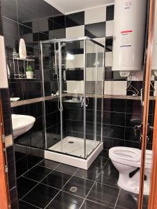 a bathroom with a glass shower and a toilet at Къща Каменар in Pomorie