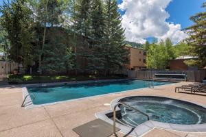 una piscina con bañera de hidromasaje en un patio en Chateau Roaring Fork Condo 31 en Aspen