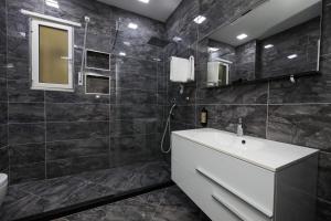 a bathroom with a white sink and a mirror at Jimi Apartments in Vlorë +57 photos