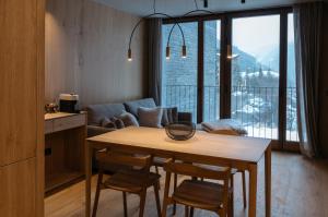 ein Wohnzimmer mit einem Tisch, Stühlen und einem Sofa in der Unterkunft ISARD RESIDENCES & SPA by Elegant Residences in El Tarter