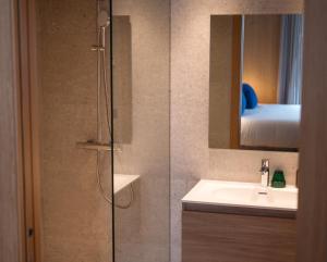 y baño con ducha, lavabo y espejo. en ISARD RESIDENCES & SPA by Elegant Residences, en El Tarter