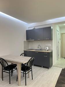 a kitchen with a table and chairs in a room at Hotel Peak in Gudauri