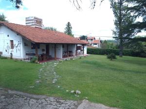 una casa con un patio de hierba delante de ella en Los Colibries en Villa General Belgrano