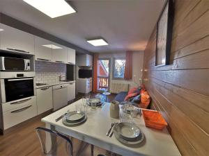 a kitchen with a table with wine glasses on it at Appartement Méribel, 2 pièces, 4 personnes - FR-1-180-604 in Les Allues