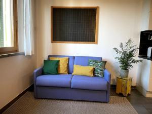 un sofá azul con almohadas coloridas en la sala de estar. en Casa giordi - intero appartamento, en Empoli