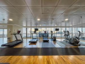 a gym with several treadmills and elliptical machines at Luxe Living in our Exquisite 1 Bedroom Apartment in Dubai