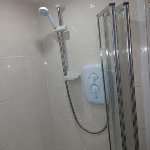 a shower with a shower head in a bathroom at The Rose in Greasbrough