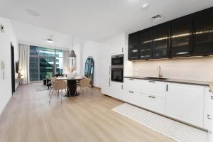 a kitchen with white cabinets and a dining table at Luxe Living in our Exquisite 1 Bedroom Apartment in Dubai