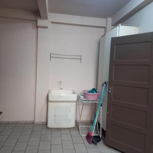 baño con aseo, lavabo y puerta en Aptos Enseada Prox Praia en São Francisco do Sul