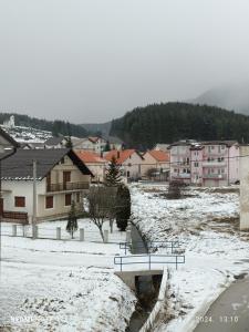 una città coperta di neve con edifici e un ponte di Apartman Iva a Kupres