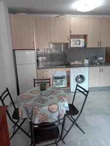 a kitchen with a table and chairs and a table and a kitchen with a table at Apartamento Mirasol con parking privado in Fuengirola