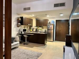 uma cozinha com um balcão e um frigorífico em Entire apartment in Remraam community em Dubai