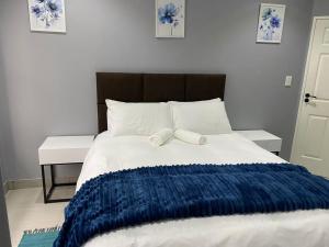 a bed with a blue and white blanket on it at Ongwe Complex - Holiday Apartment in Swakopmund