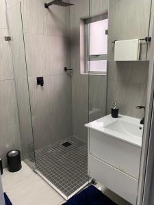 a bathroom with a shower and a sink at Ongwe Complex - Holiday Apartment in Swakopmund